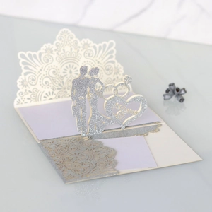 Detail of silver glitter laser-cut pop-up wedding invitation with Mr & Mrs silhouette