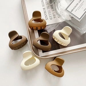 Set of 6 matte acrylic hair claw clips in earthy Morandi colors on a minimalist tray