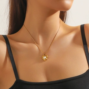 Elegant gold-plated heart pendant necklace with pearl on a model in soft natural light