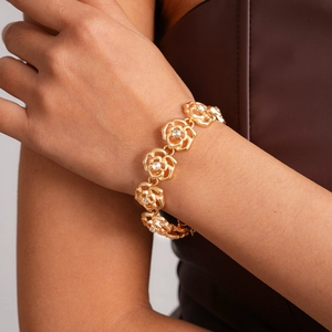 Detailed view of a gold rose necklace featuring hollow petals and central sparkling zircons