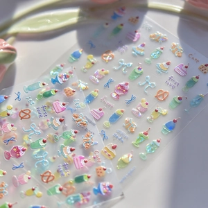 Vue macro d'autocollants 3D pour ongles avec motifs de desserts et nœuds pailletés