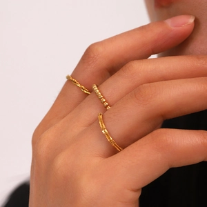 Three-piece stackable gold stainless steel rings with twisted and beaded texture designs