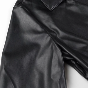 Gros plan sur la texture en cuir PU noir montrant le grain fin et le fini brillant