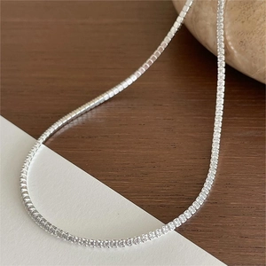 Macro detail of a 925 sterling silver tennis necklace with sparkling cubic zirconia stones