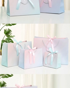 Detail showing various sizes of pink and blue gradient gift bags with silk handles