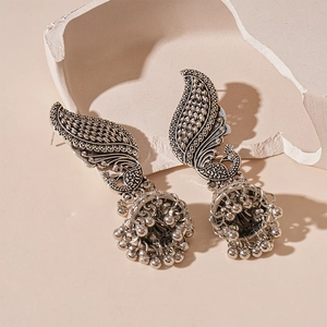 Détail de boucles d'oreilles Jhumka paon vintage avec cloche ornée et glands de perles