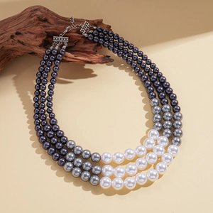 Three-layer gradient faux pearl necklace with silver multi-row clasp on rustic wood