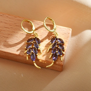 French style gold earrings with purple marquise zircon leaves on a rustic wood stand