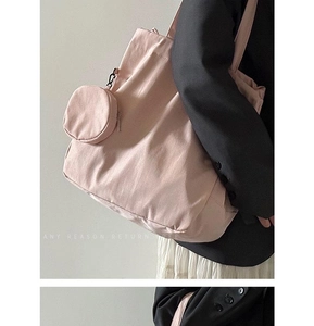 Detail of light pink nylon tote bag with matching round coin purse on shoulder strap