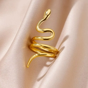 Minimalist vintage snake wrap ring in gold finish on champagne silk fabric background