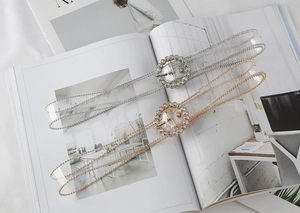 Detail of elegant gold and silver double-row bead waist chains with rhinestone buckles