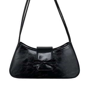 Minimalist black baguette shoulder bag with a sleek pleated leather bow decoration