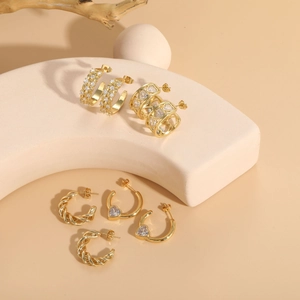 Detailed view of 14K gold plated hoop earrings with heart shapes and twisted textures