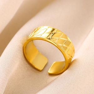 Dettaglio anello in acciaio inossidabile oro 18K con trama geometrica a rombi incisi