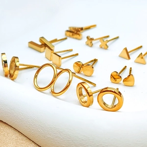 Vista macro detallada del conjunto de pendientes geométricos bañados en oro