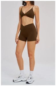 Detail of dark brown yoga set featuring thin straps and V-cross high waist shorts
