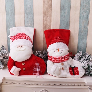 Detail of red and white knitted Christmas stockings with 3D Santa and Snowman dolls