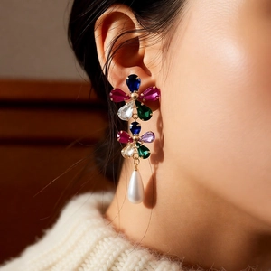 Détail de boucles d'oreilles fleur plaquées or 18 carats avec cristaux et perle