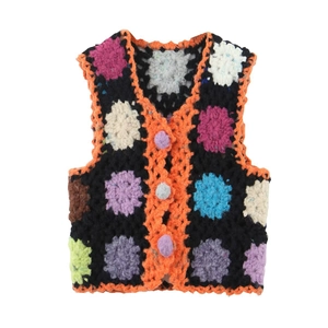 Texture de maille détaillée du gilet au crochet fait main avec motifs floraux colorés