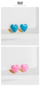 Detail view of colorful heart-shaped enamel hoop earrings in blue and pink tones