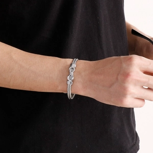 Men's silver stainless steel infinity knot cable cuff bracelet worn on a wrist
