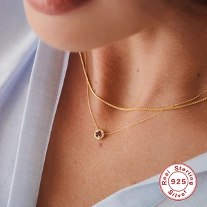 Layered gold 925 sterling silver necklace with a round red gemstone pendant and zircons