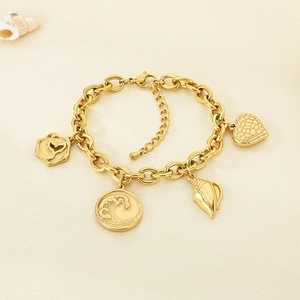 Detailed close-up of golden ocean-themed bracelet with whale tail and shell charms