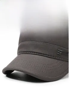 Close-up of reinforced stitching on brim and embossed side lettering of gray canvas cap