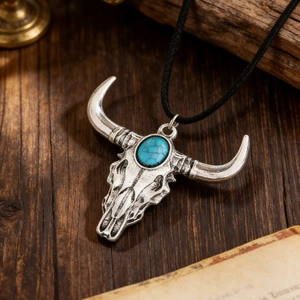Detailed view of vintage bull skull pendant with turquoise stone and antique silver finish