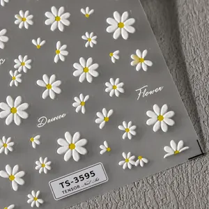 Macro shot of 5D embossed white daisy nail art stickers and floral text details