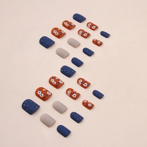 Short square press-on nails with blue and orange floral patterns in a matte finish