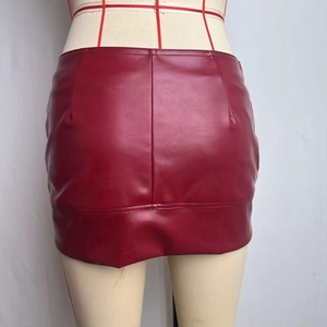 Macro view of burgundy PU leather mini skirt with matte texture and central back seam detail