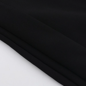 Detail shot of heavy black fabric texture with diagonal folds for slim fit dress