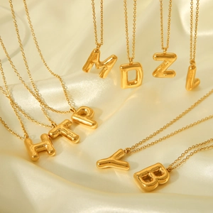 Golden 3D puffy bubble letter necklaces on silk fabric, chunky metal alphabet pendants