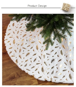 Detail of white plush Christmas tree skirt with elegant gold foil feather patterns