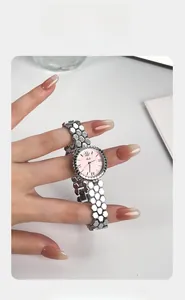 Women's quartz watch with honeycomb silver strap and pink dial shown on a wrist