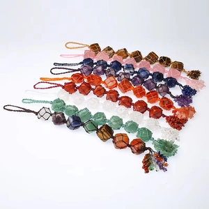 Détail d'un pendentif en cristaux naturels tissé à la main avec franges en pierres