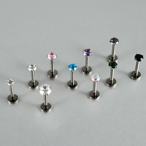 Detailed view of G23 titanium flat back studs with colorful round zircon settings
