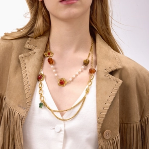 Dettaglio di una collana vintage multistrato con pietre preziose colorate e perle su un modello