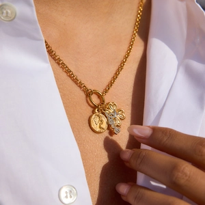 Detail of 18K gold-plated double pendant necklace with clover and coin on model
