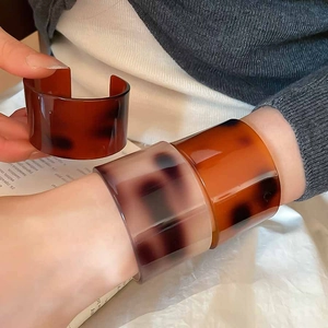 Detail of wide acetate cuff bracelet with tortoiseshell pattern on a model wrist