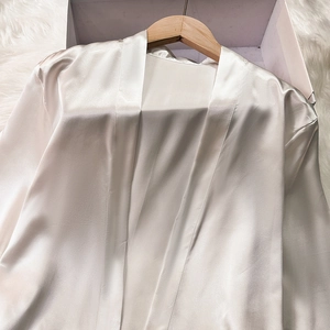 Lustrous white satin bathrobe in gift box featuring smooth silk fabric and a premium texture