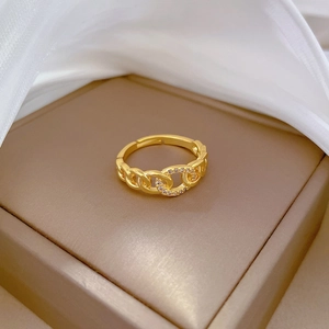 Detailed view of gold chain ring with micro-diamonds on a premium leather tray
