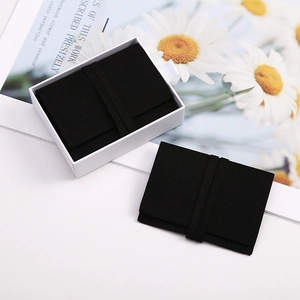 Detail of premium black velvet jewelry pouch with elegant white drawer gift box packaging