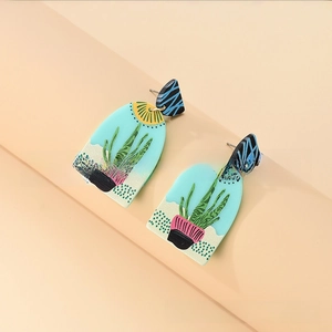 Close-up of bohemian blue arch earrings with succulent plant patterns and silver studs