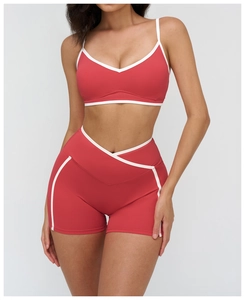 Detail of high-waist yoga set in coral red with contrast white piping and V-shape waistband