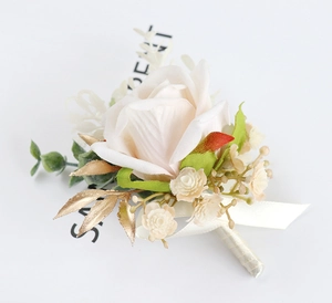 Detailed view of artificial pink rose boutonniere with golden leaves and ribbon stem