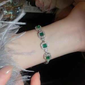 Detail view of emerald green crystal bracelet with shimmering cubic zirconia on wrist