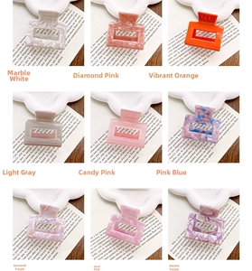 Macro display of nine colorful acetate hair claws with marble textures and solid colors