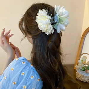 Detail of white handmade fabric lotus hair claw clip on elegant half-up hairstyle
